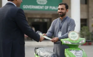 A government official hands keys to a recipient standing next to a green electric scooter labeled "Govt Employee E-Bike Scheme - 2026," with the Government of Punjab building visible in the background.